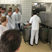 Mehrere Personen in Schutzkleidung in Industrieküche
